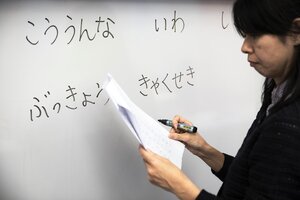 Lärare skriver japanska tecken på tavlan