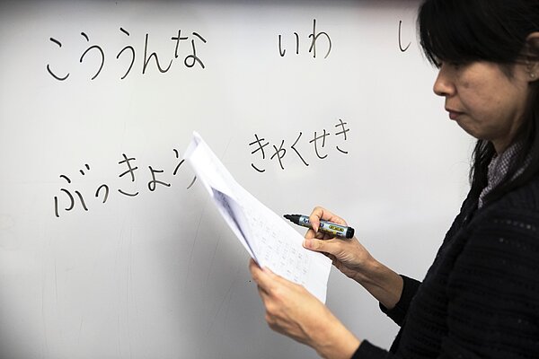 Lärare skriver japanska tecken på tavlan