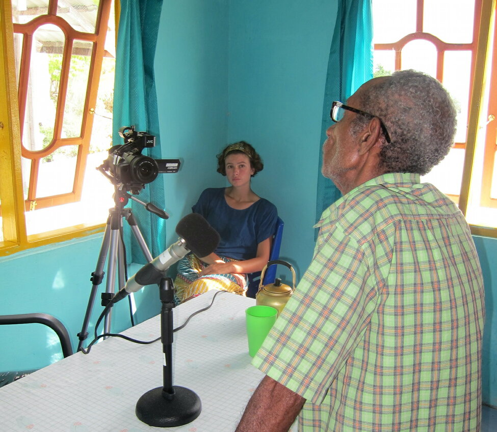 Eline Visser tillsammans med en informant i ett färgstarkt rum på Karasöarna