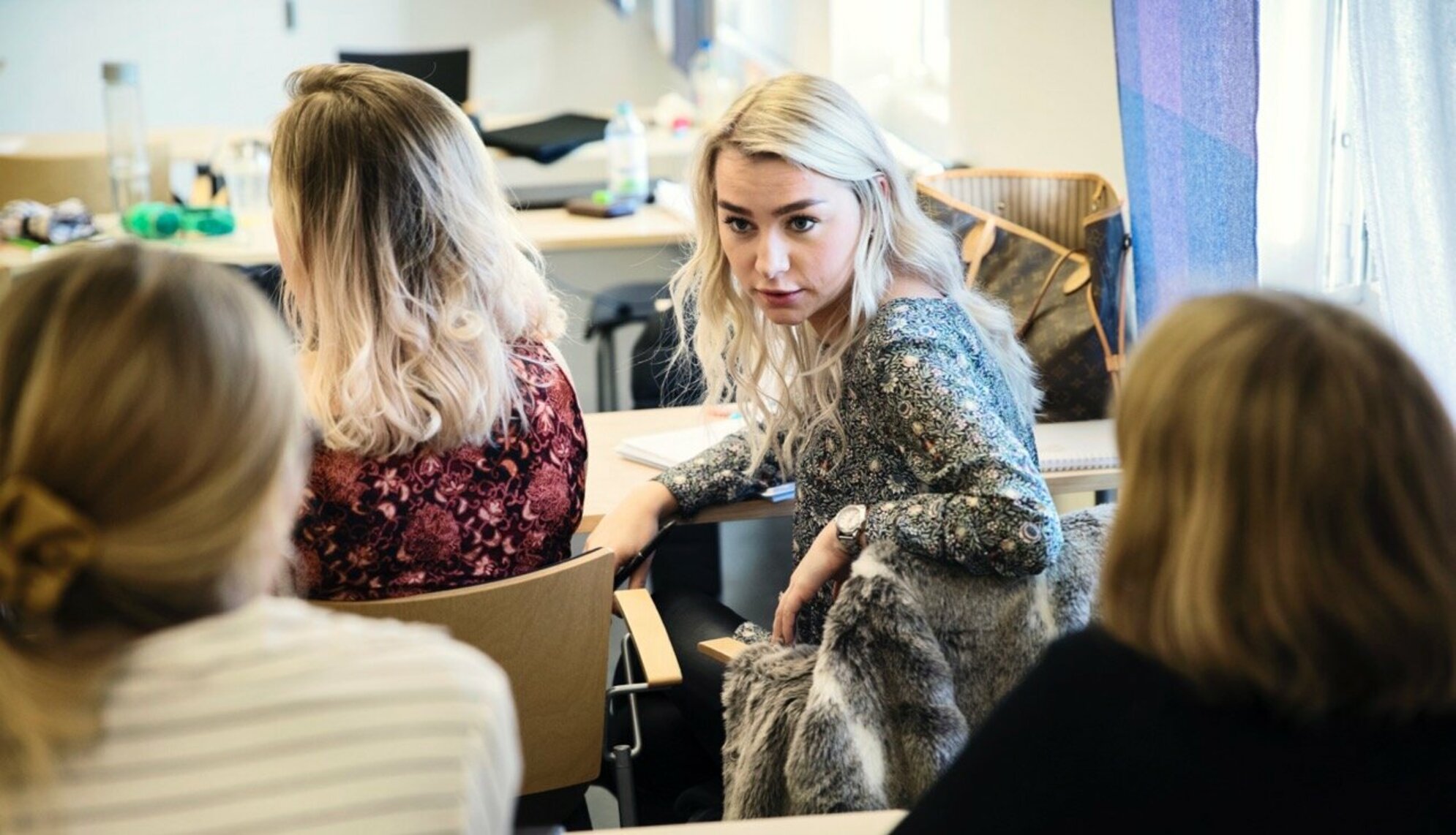 Fyra kvinnliga studenter i ett klassrum. 