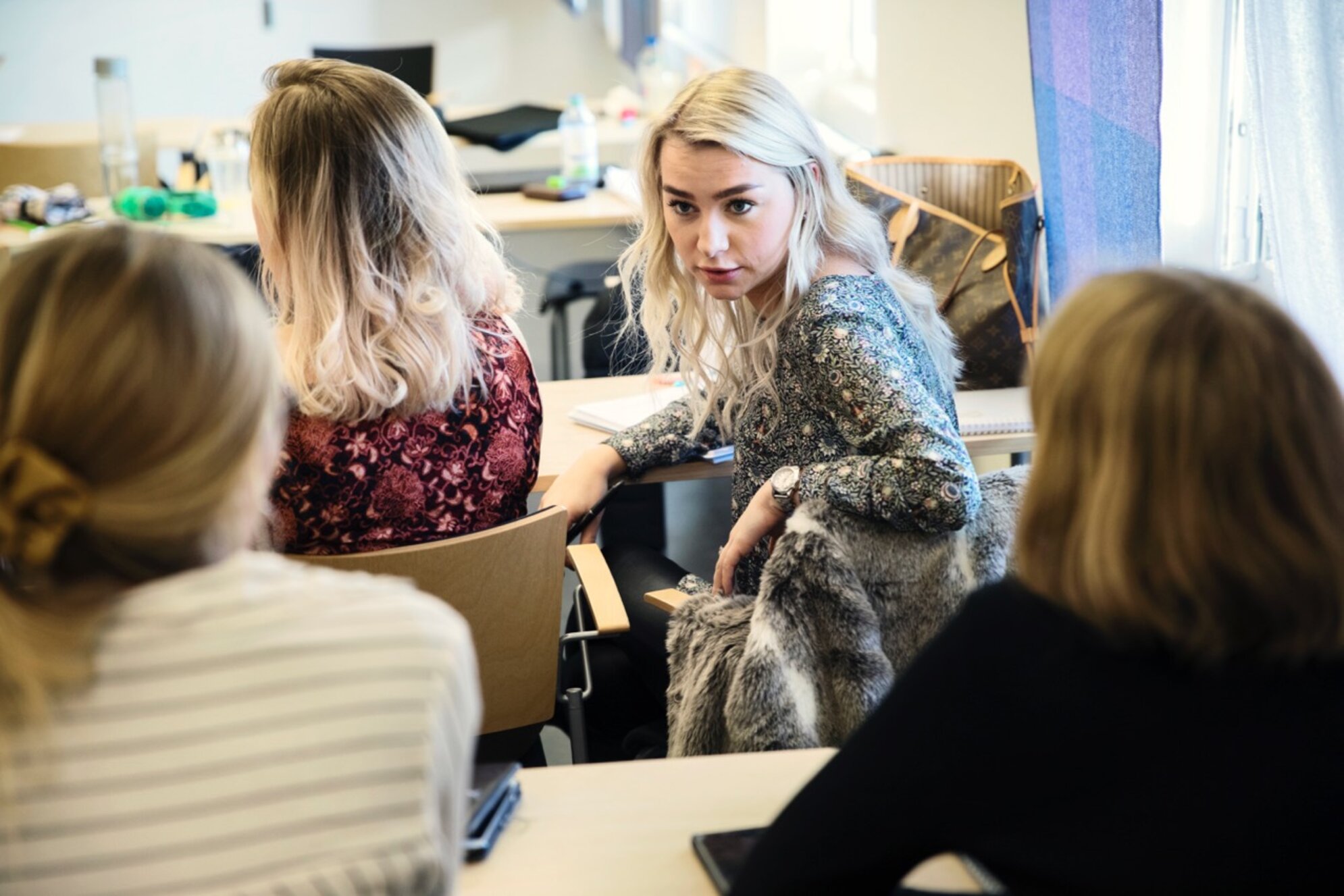 Studenter samtalar i en lektionssal. 