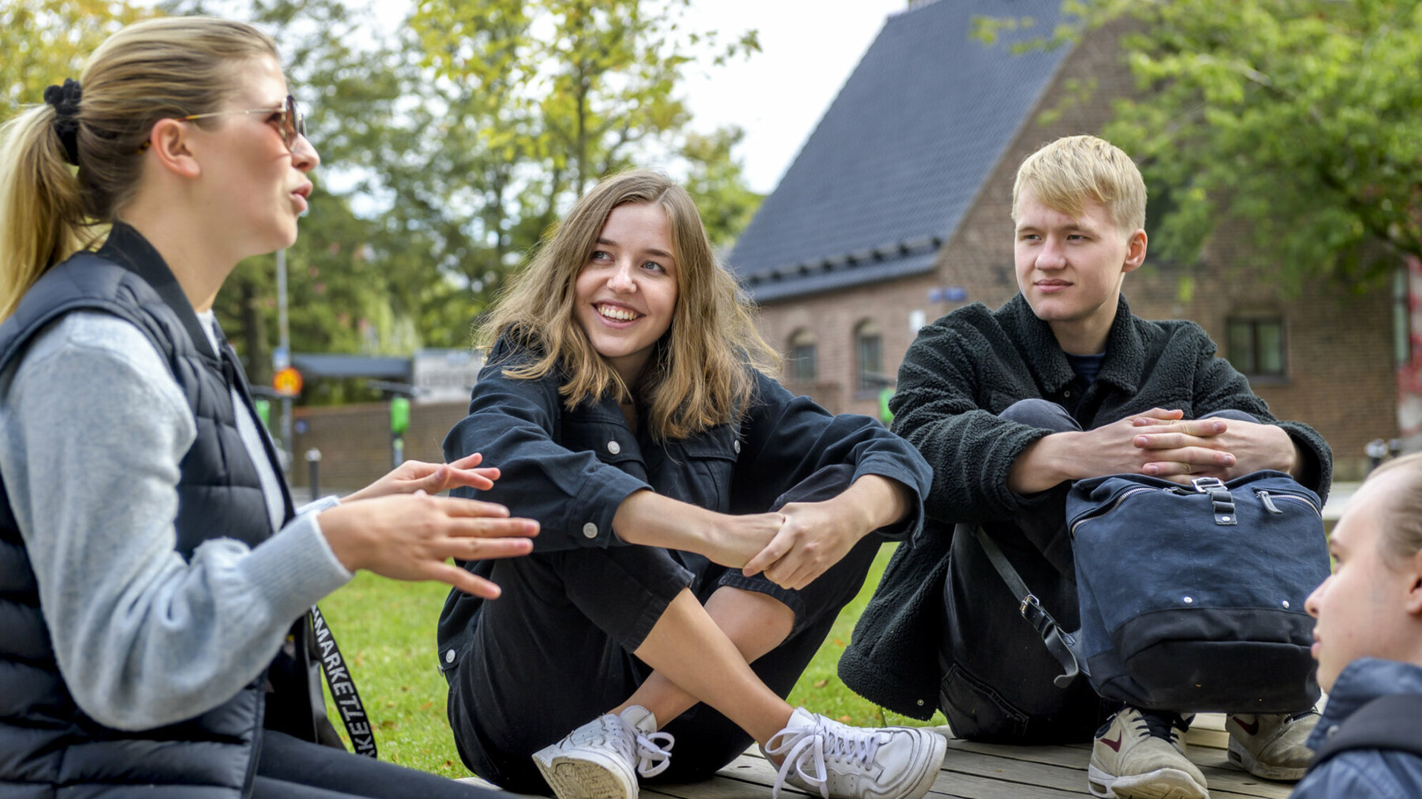 Studenter som sitter på en bänk. 